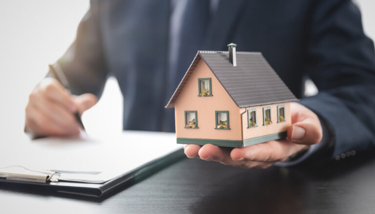 Real estate agent is holding a house model